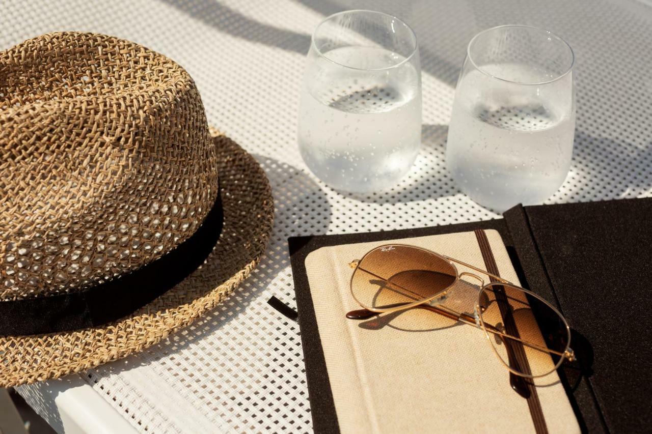 Toscana Charme Resort Tirrenia Esterno foto A hat, sunglasses, and a book
